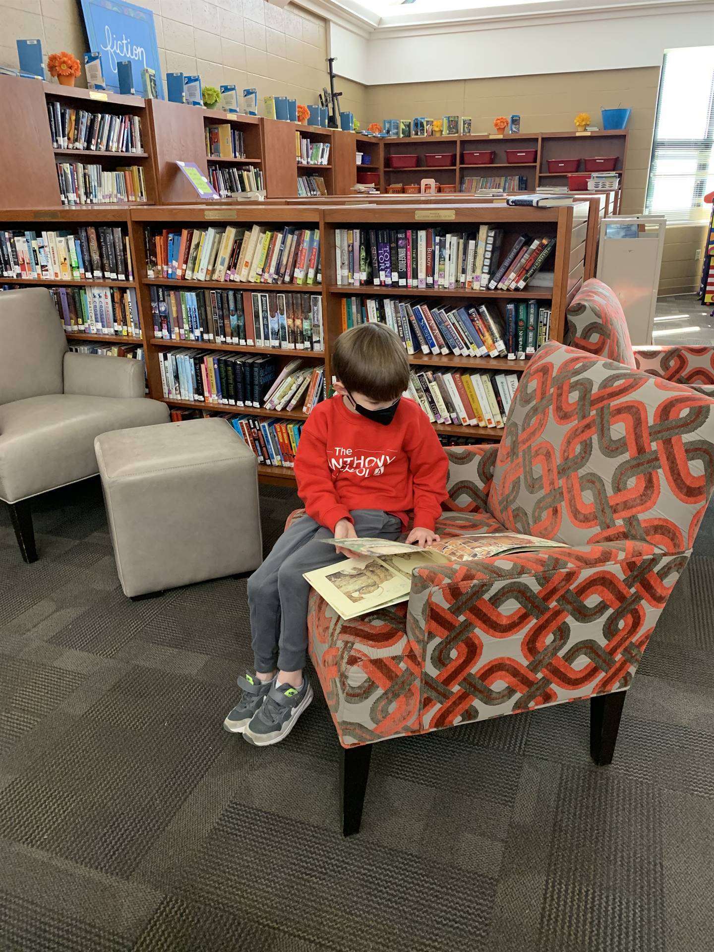 kindergartener reading a book in the library